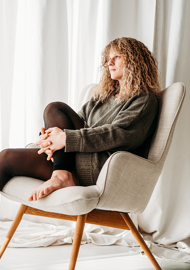 Lisa Turcanu sitzt in einem Sessel und blickt nachdenklich zur Seite.